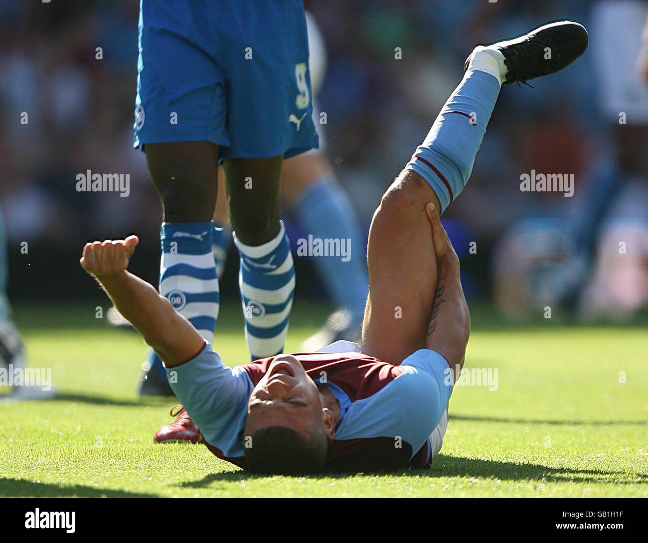 Soccer - UEFA Intertoto Cup - Third Round - Second Leg - Aston Villa v Odense Boldklub - Villa Park. Aston Villa's Wilfred Bouma (on floor) clutches his leg after dislocating his ankle after a collision with Odense BK's Djilby Fall Stock Photo