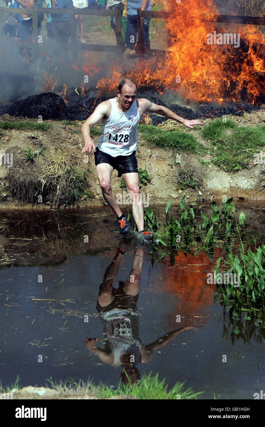Competitors in the Nettle Warrior Tough Guy competition struggle through the 'fiery holes', one of the many obstacles on the 6 mile course in Perton, Wolverhampton. Stock Photo