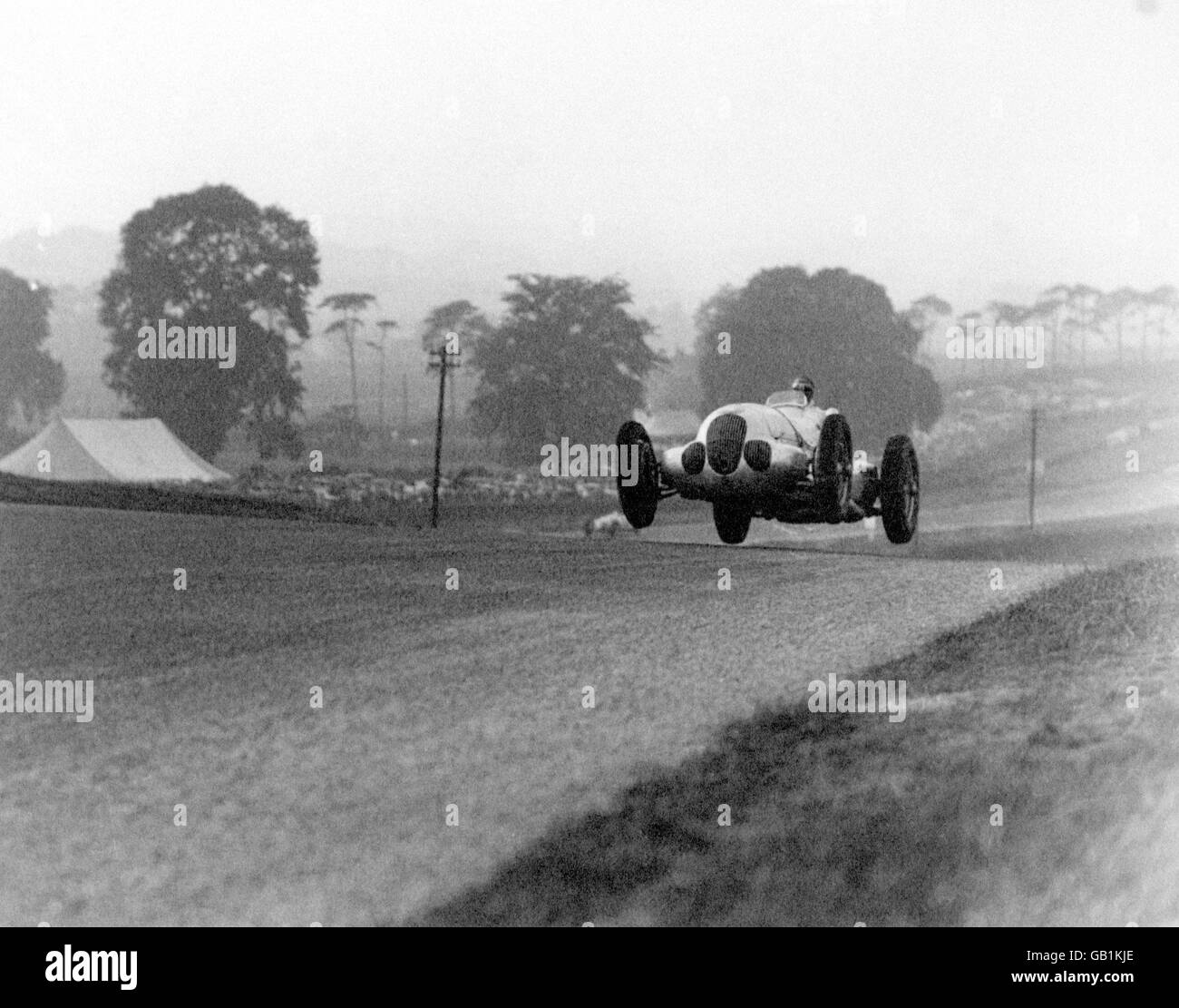 Manfred von Brauchitsch takes off as he crests a hill Stock Photo