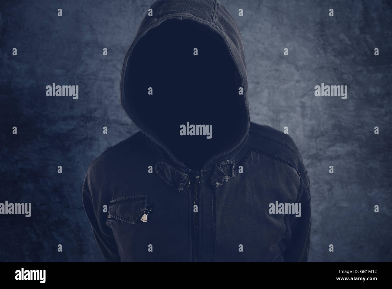 Unrecognizable hooded soccer hooligan portrait, spooky faceless criminal person in jacket with hood Stock Photo