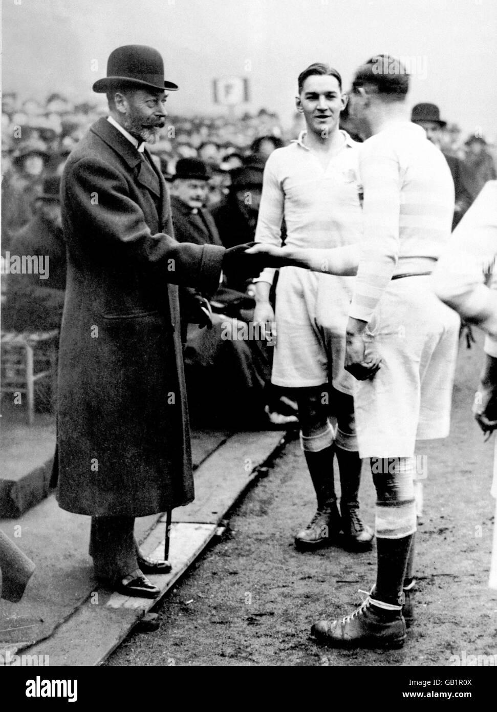 Cambridge University captain Geoffrey Conway (c) introduces his team to HM King George V (l) before the match (the last varsity match to be played at Queen's) Stock Photo