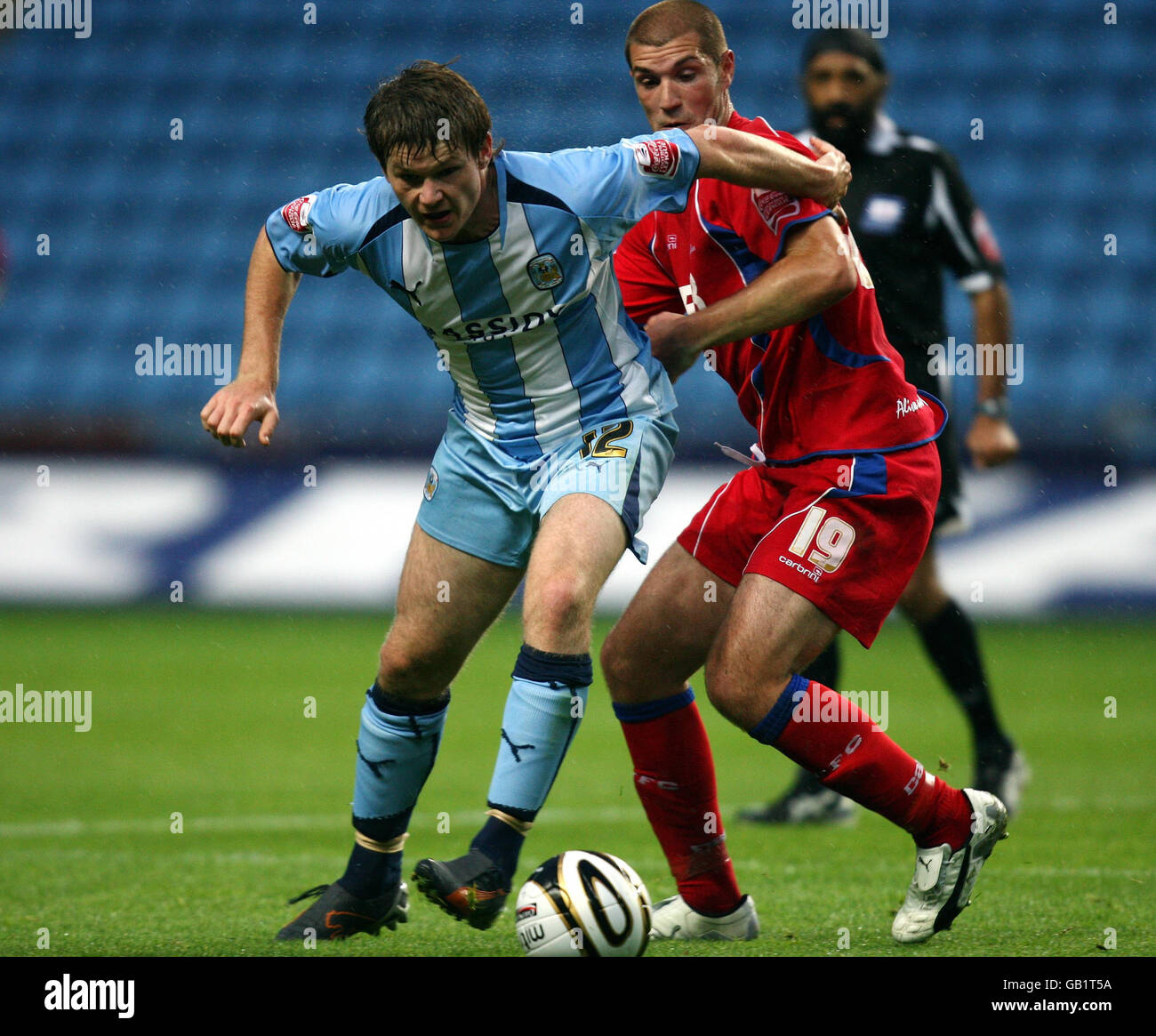 Coventry City's Aron Gunnarsson (left) is challenged by Aldershot's Ben Harding during the Carling Cup match at the Ricoh Arena, Coventry. Stock Photo