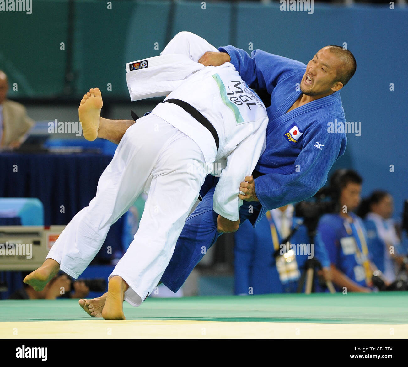 Japan's Keiji Suzuki (blue) in action against Mongolia's Tuvshinbayar Naidan in the Men's -100kg class at Beijing's University of science and technology Gymnasium Stock Photo