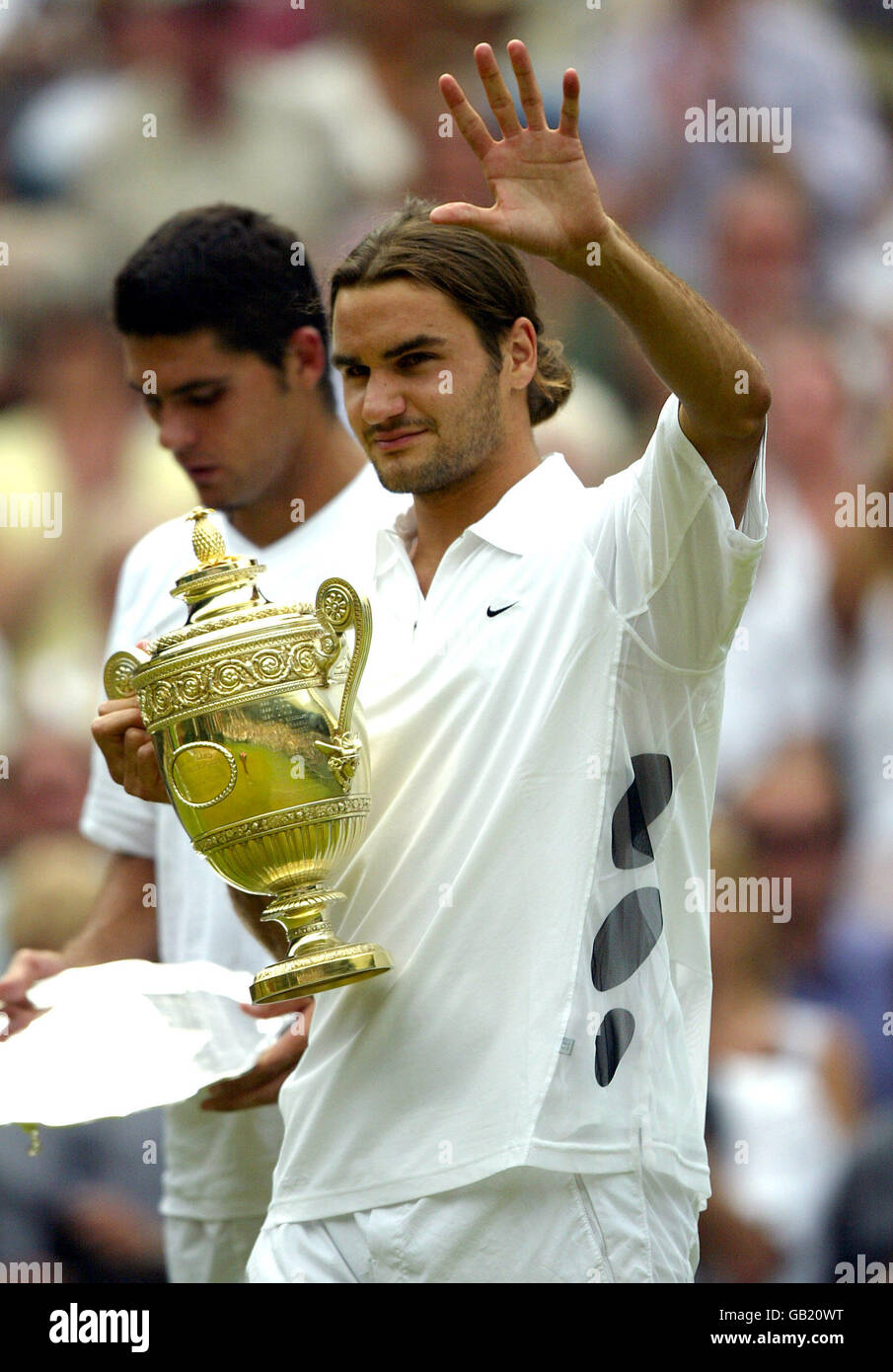 Tennis - Wimbledon 2003 - Men's Final - Mark Philippoussis v Roger Federer. Roger  Federer walks off with the winners cup as Mark Philippoussis looks on  dejected Stock Photo - Alamy