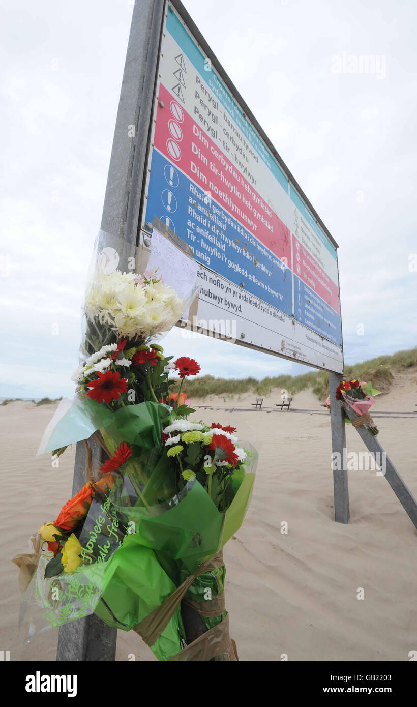 Floral tributes on the beach at Cefn Sidan, near Burry Port, west Wales, where a 16-year-old boy died after a tunnel dug in sand dunes collapsed last night. Stock Photo