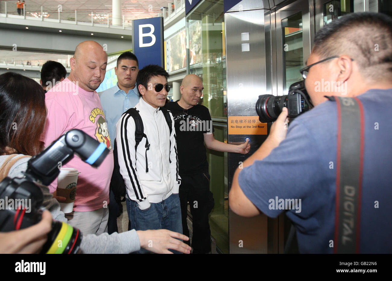 Chinese pop star Andy Lau at Beijing airport (dark glasses) as preparations continue for the start of the Beijing Olympics Stock Photo