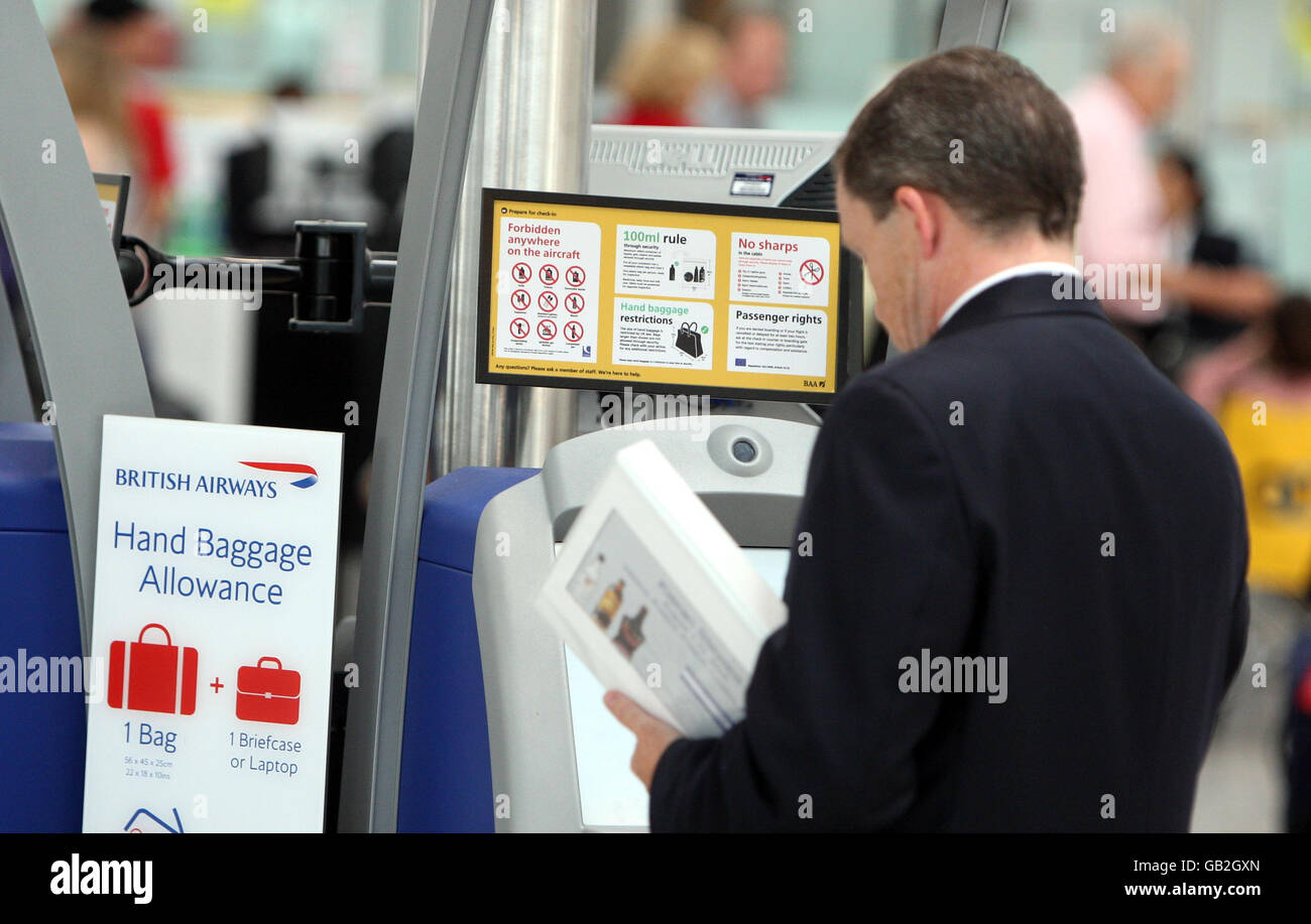 Signs inform passengers of hand baggage restrictions as they check in at Heathrow Airport's