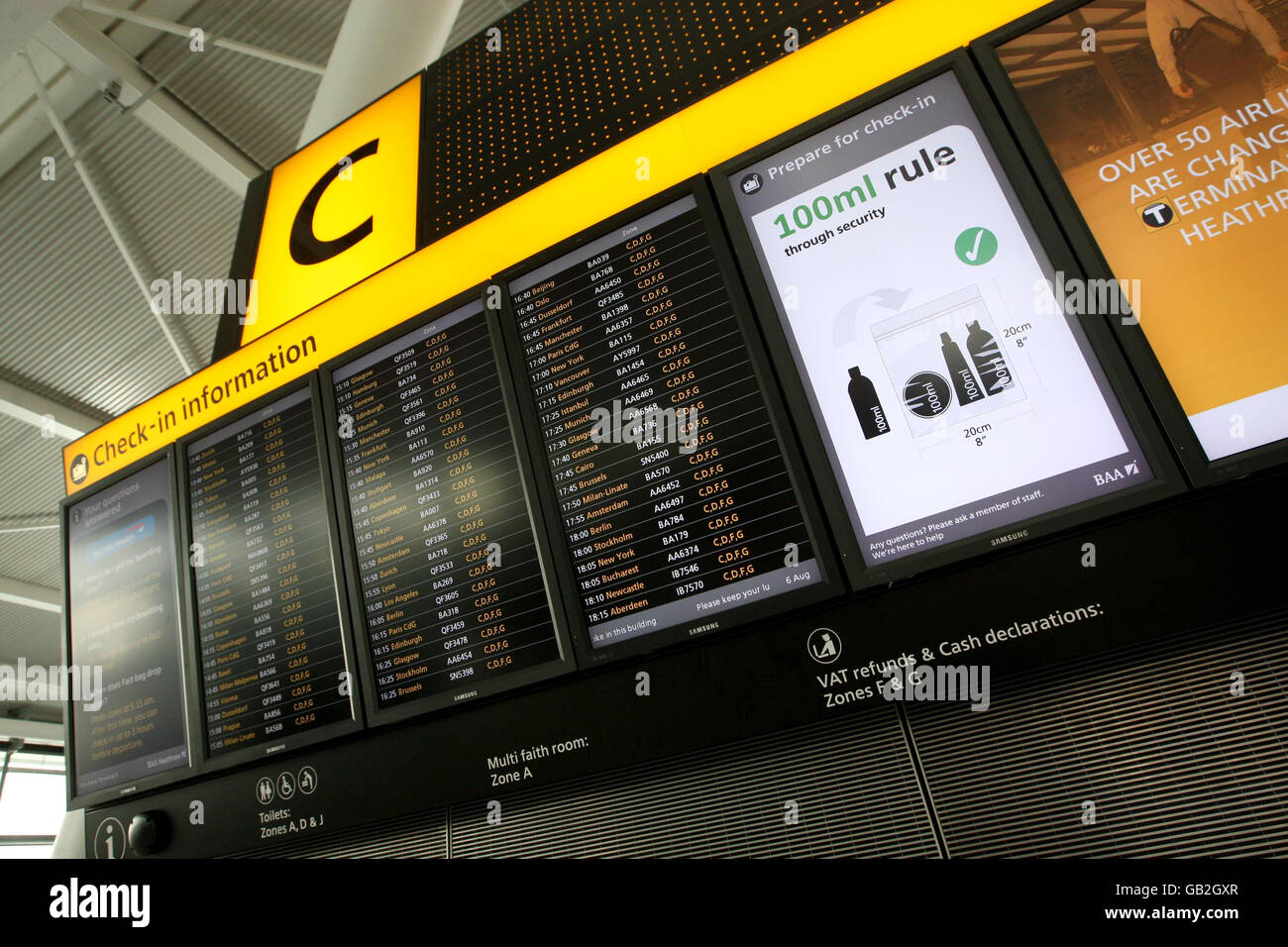 Signs inform passengers of hand baggage restrictions as they check in at Heathrow Airport's