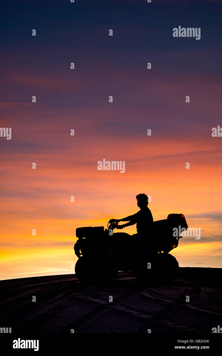 Man on quad Bike during Sunset Stock Photo