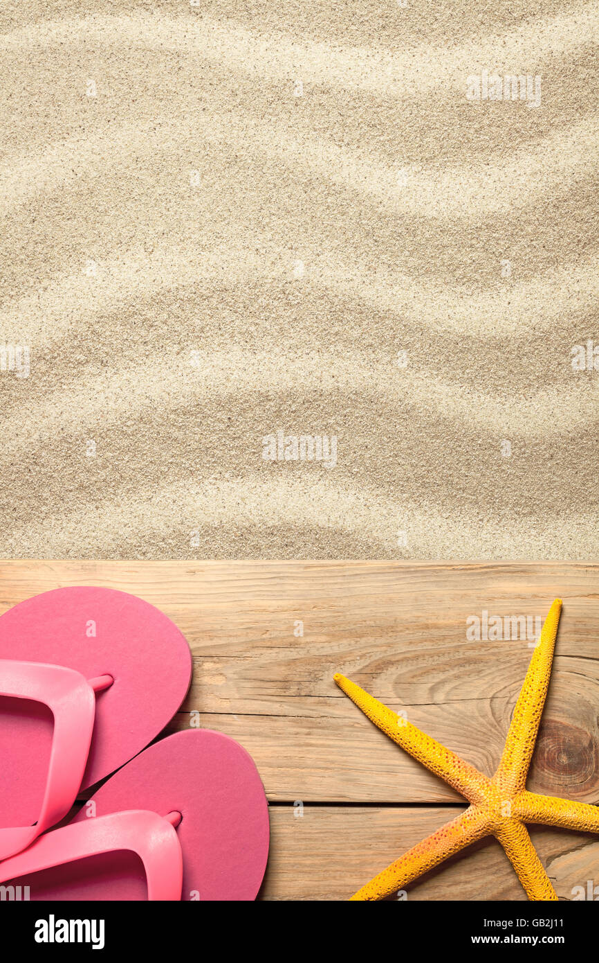 Summer concept with pink flip flops and yellow starfish on sandy beach ...