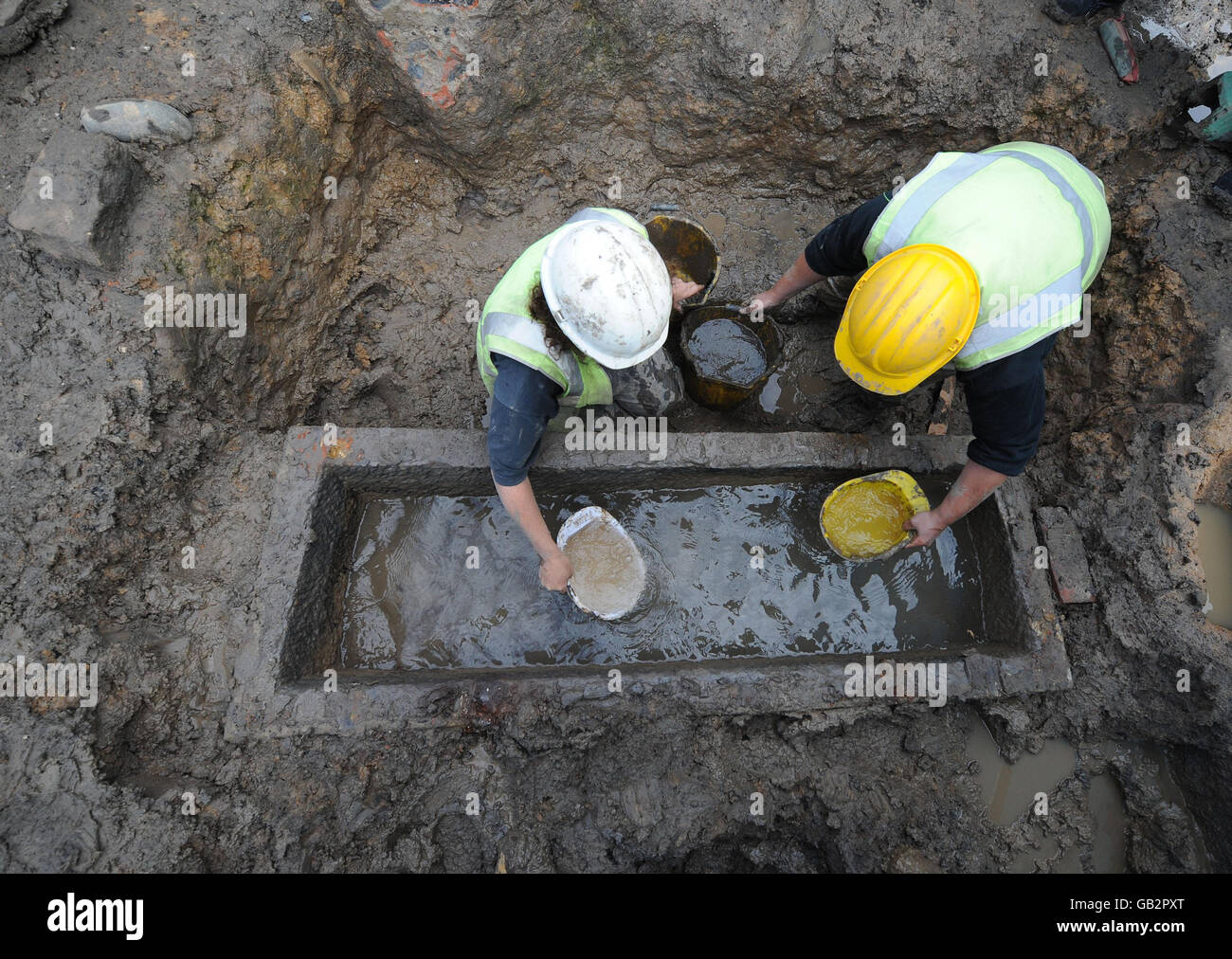 Archaeologists from Durham University lift the lid of a roman stone sarcophagus, uncovered at a dig on the site of a former chapel and office buildings. Stock Photo