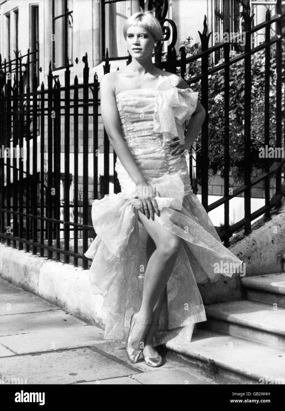 Frills and bows a prominent feature of this designer collection of fashions by Christina Stambolian. The evening dress in pale blue silk organza is modelled by Casey whose symmetrical bobbed haircut adds to the allure. Stock Photo