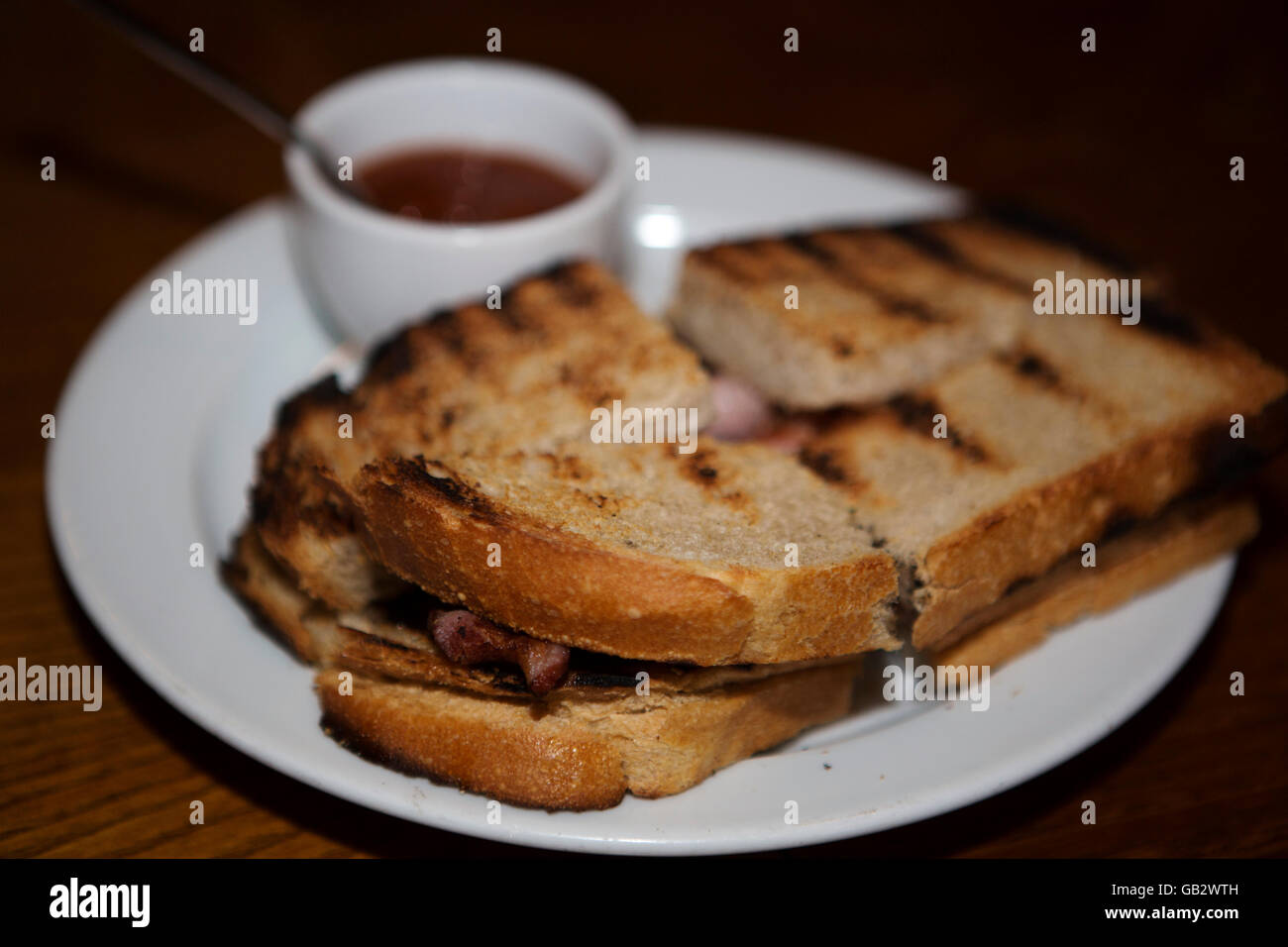 A bacon sandwich, made with toasted bread, served in London, England