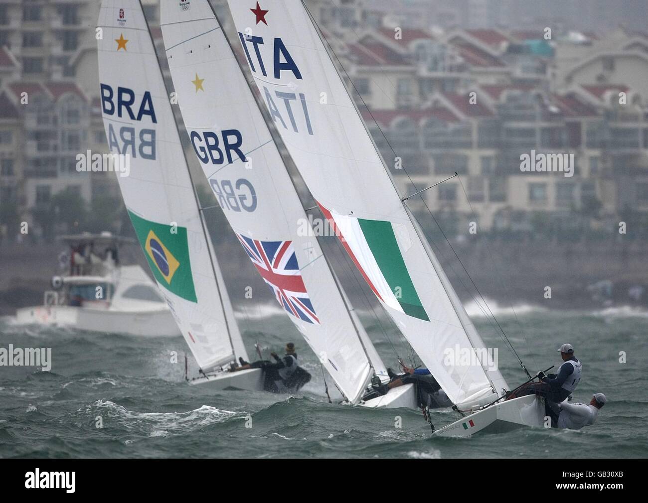 (l-r) Brazil's Robert Scheidt and Bruno Prada, Great Britain's Iain Percy and Andrew Simpson and Italy's Diego Negri and Luigi Viale sail in the final race of the Men's Star class at the Qingdao Olympic Sailing Center on day 13 of the 2008 Olympic Games in Beijing. Stock Photo