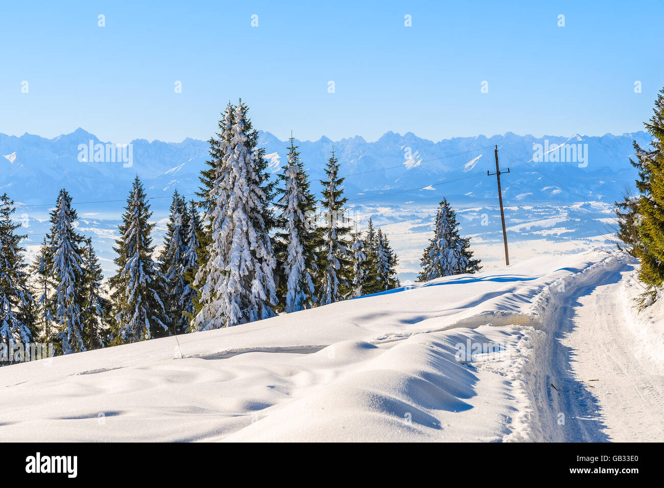 Winter trail in Gorce Mountains and panorama of Tatra Mountains in background, Poland Stock Photo