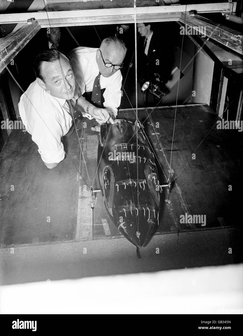 (L-R) Donald Campbell and Leo Villa test the aerodynamics of a model of the new Bluebird in the wind tunnel at Imperial College Stock Photo