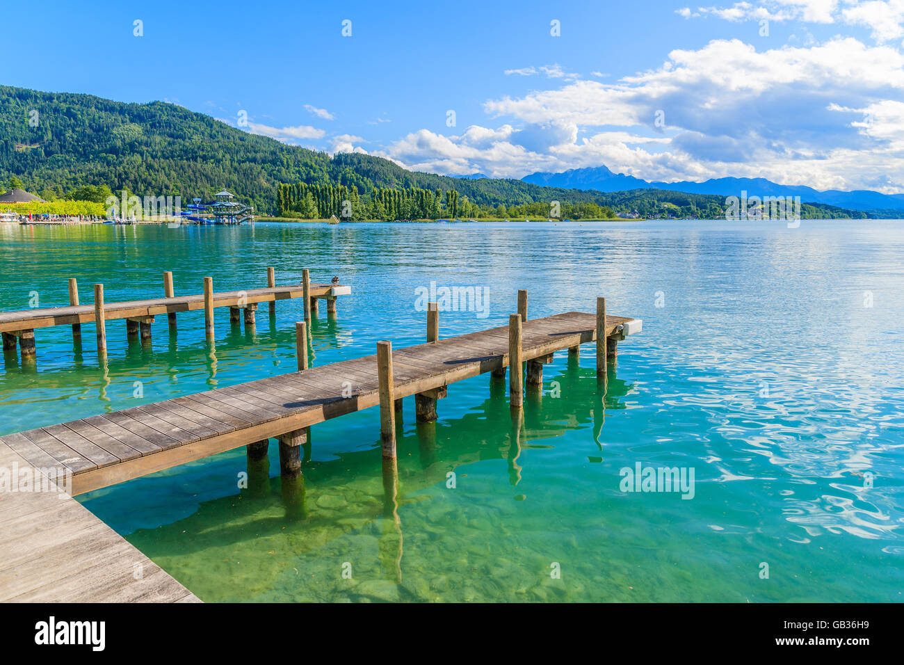 Wooden pier for mooring boats on Worthersee lake on beautiful summer day, Austria Stock Photo