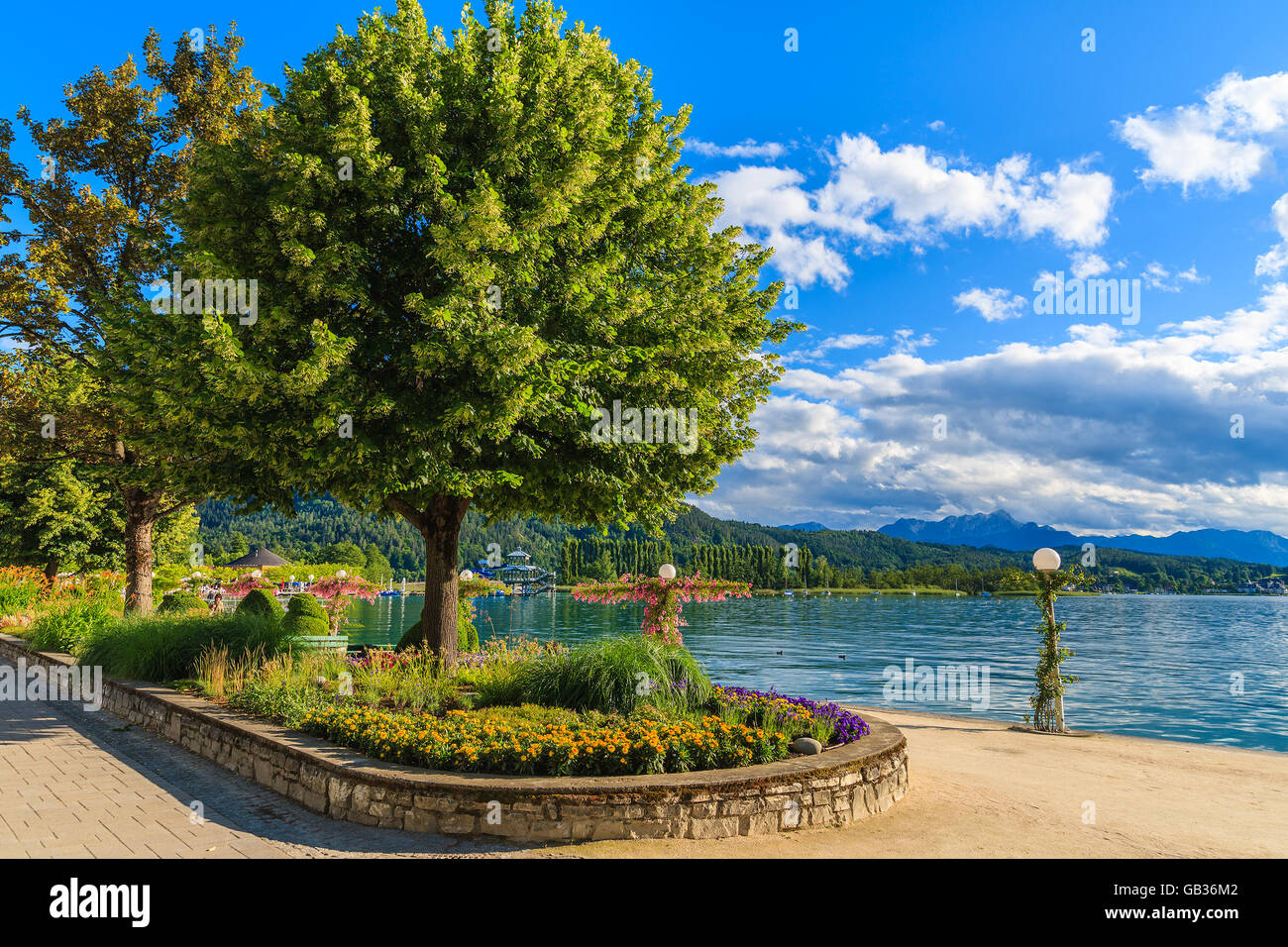 Promenade with flowers along Worthersee lake on beautiful summer day, Austria Stock Photo