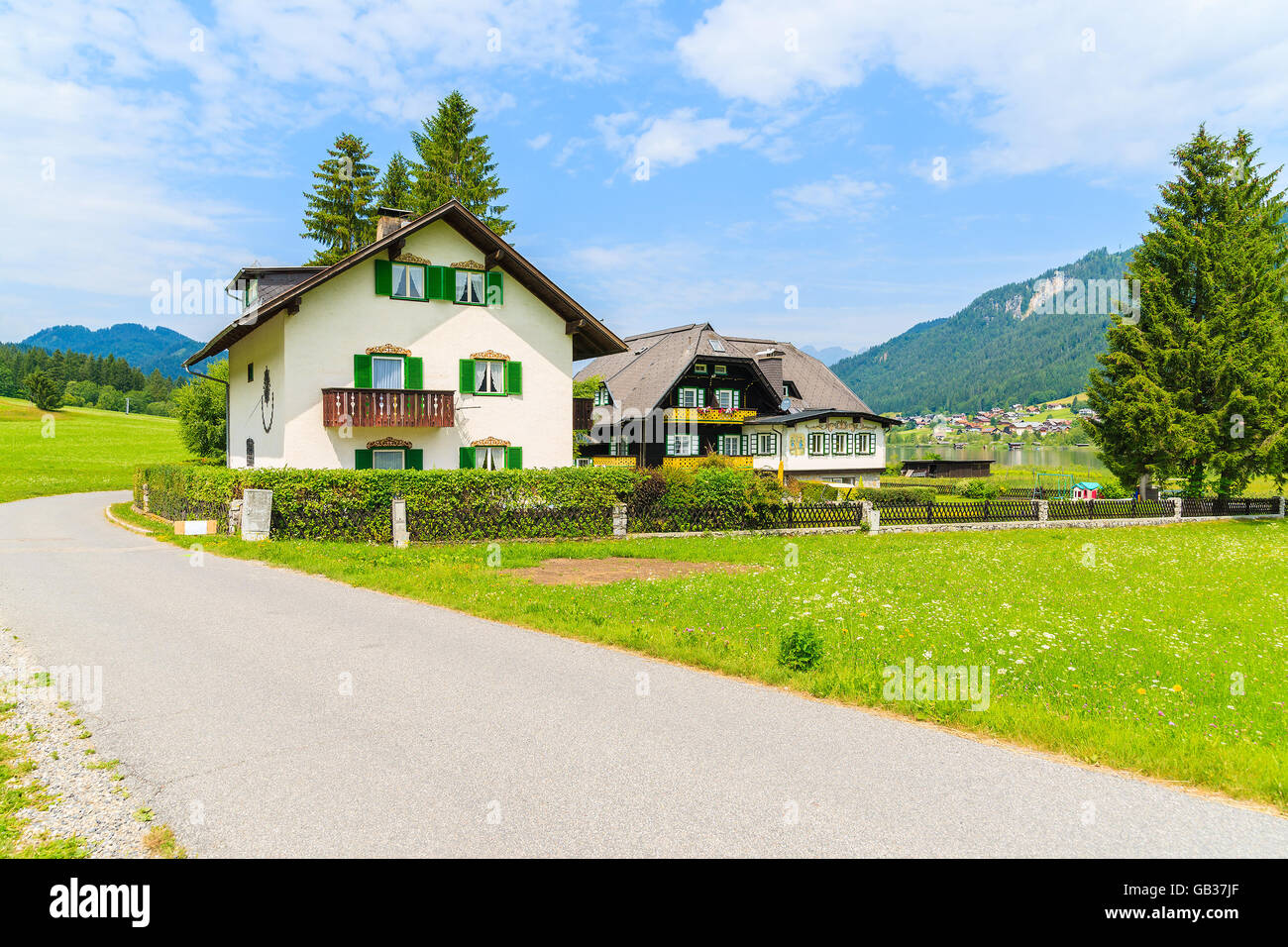 Walking lakeside promenade with view of typical alpine mountain houses in summer landscape of Weissensee lake, Austria Stock Photo