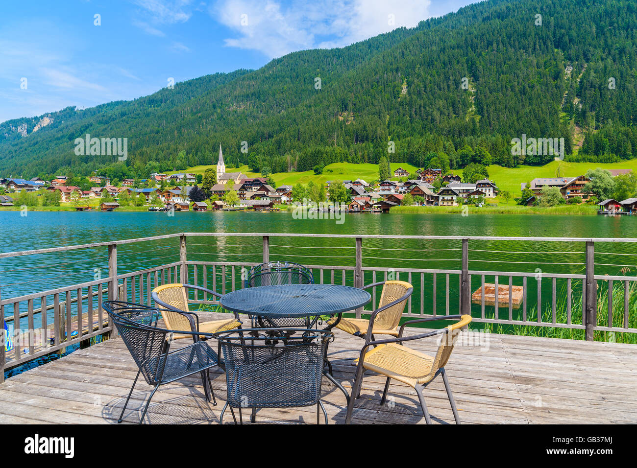 Chairs around table on terrace with view of Weissensee lake in summer time, Austria Stock Photo