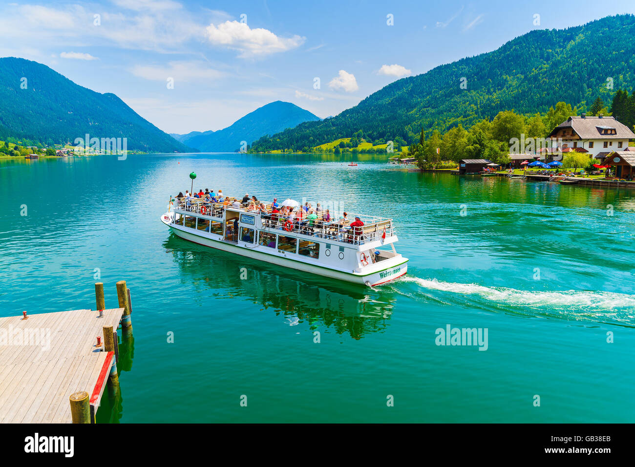WEISSENSEE LAKE, AUSTRIA - JUL 6, 2015: tourist boat 'Weissensee' departing for a cruise around Weissensee lake in summer landsc Stock Photo