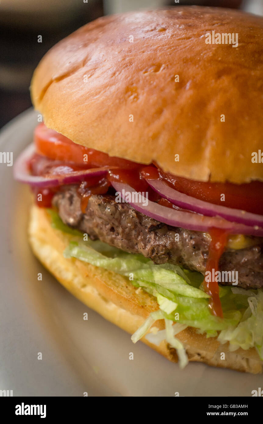 Cheeseburger on a whole wheat bun with steak fries on the side Stock Photo