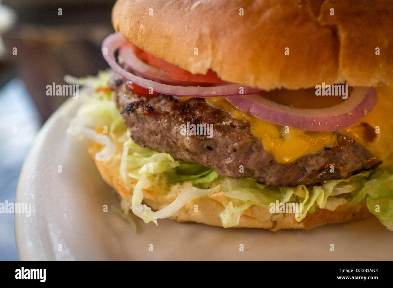 Cheeseburger on a whole wheat bun with steak fries on the side Stock Photo