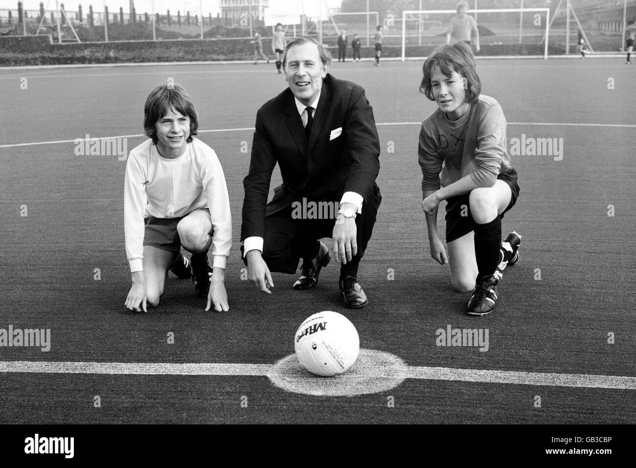 Chairman of the Sports Council, Dr Roger Bannister, with the captains of Highbury Grove School and Holloway School at the centre spot of the new synthetic pitch Stock Photo