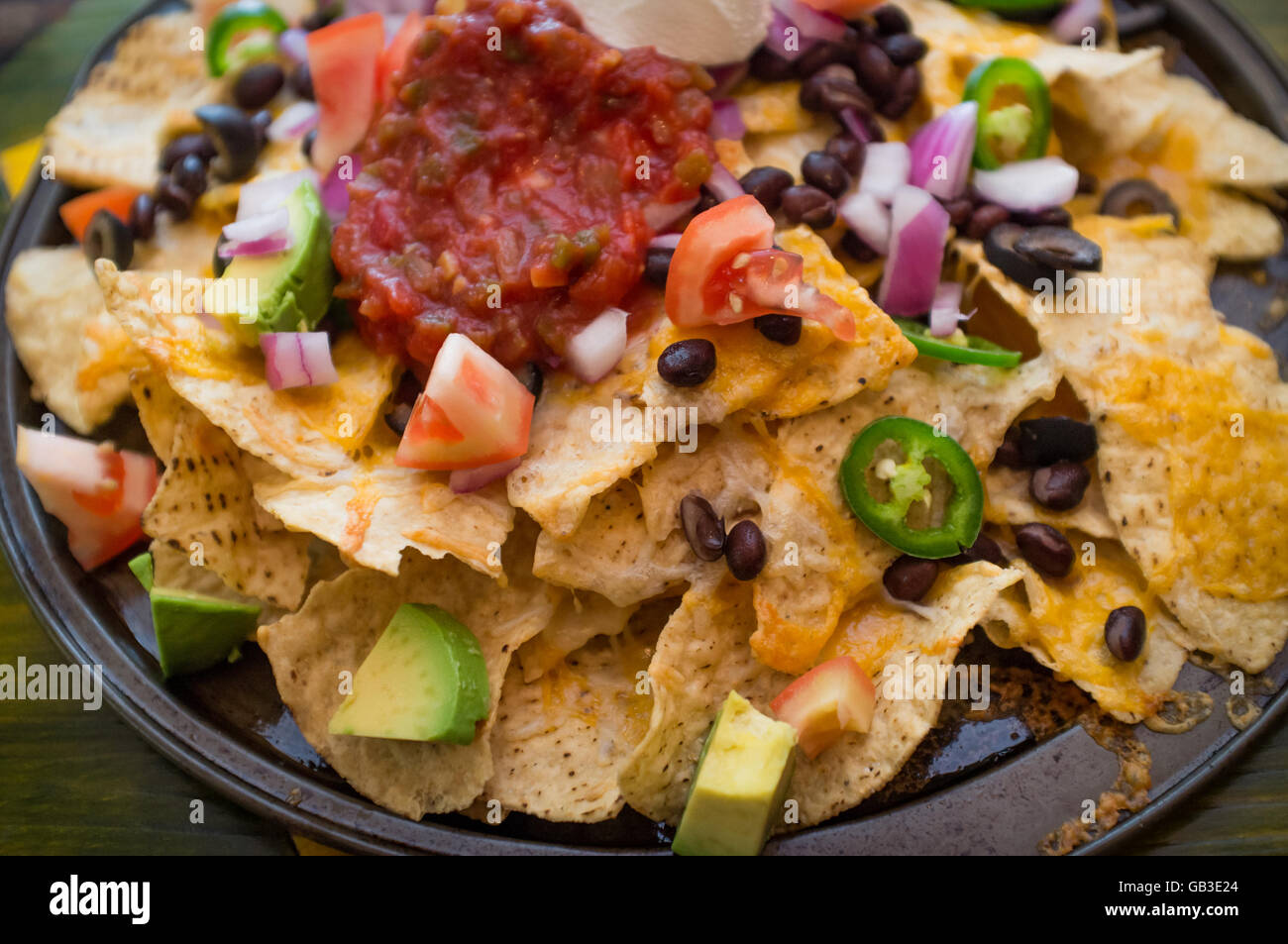 Vegetarian nachos loaded with toppings like jalapeno and black olives Stock Photo Alamy
