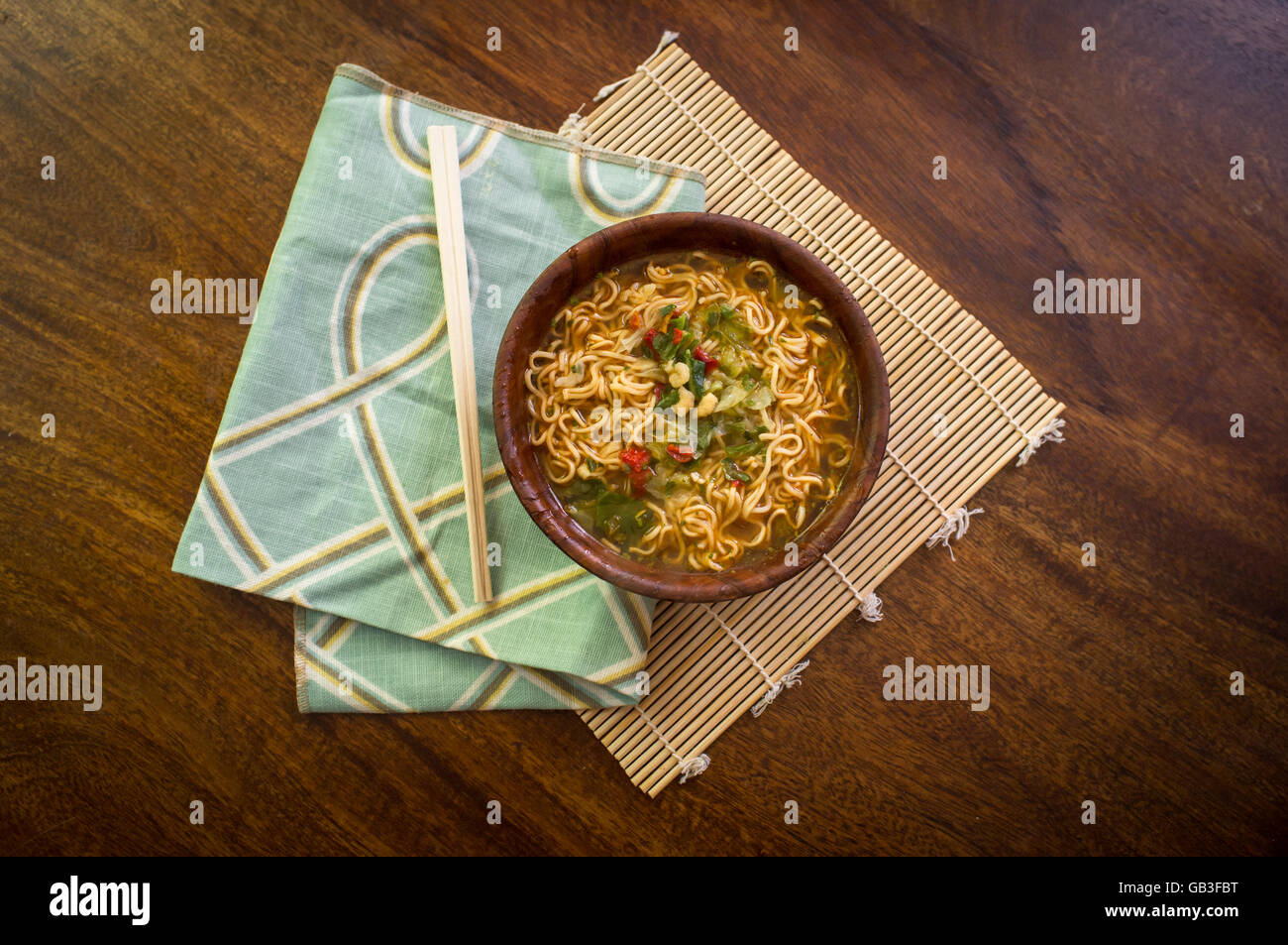 Spicy asian ramen noodle soup with chopsticks in wooden bowl Stock