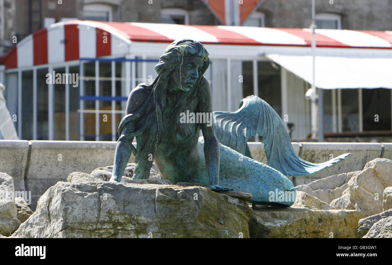 General view of the mermaid sculpture on the rocks of the breakwater at the Royal Yacht Squadron in Cowes on the Isle of Wight. It was modelled on the former Olympic swimmer Sharron Davies. Stock Photo