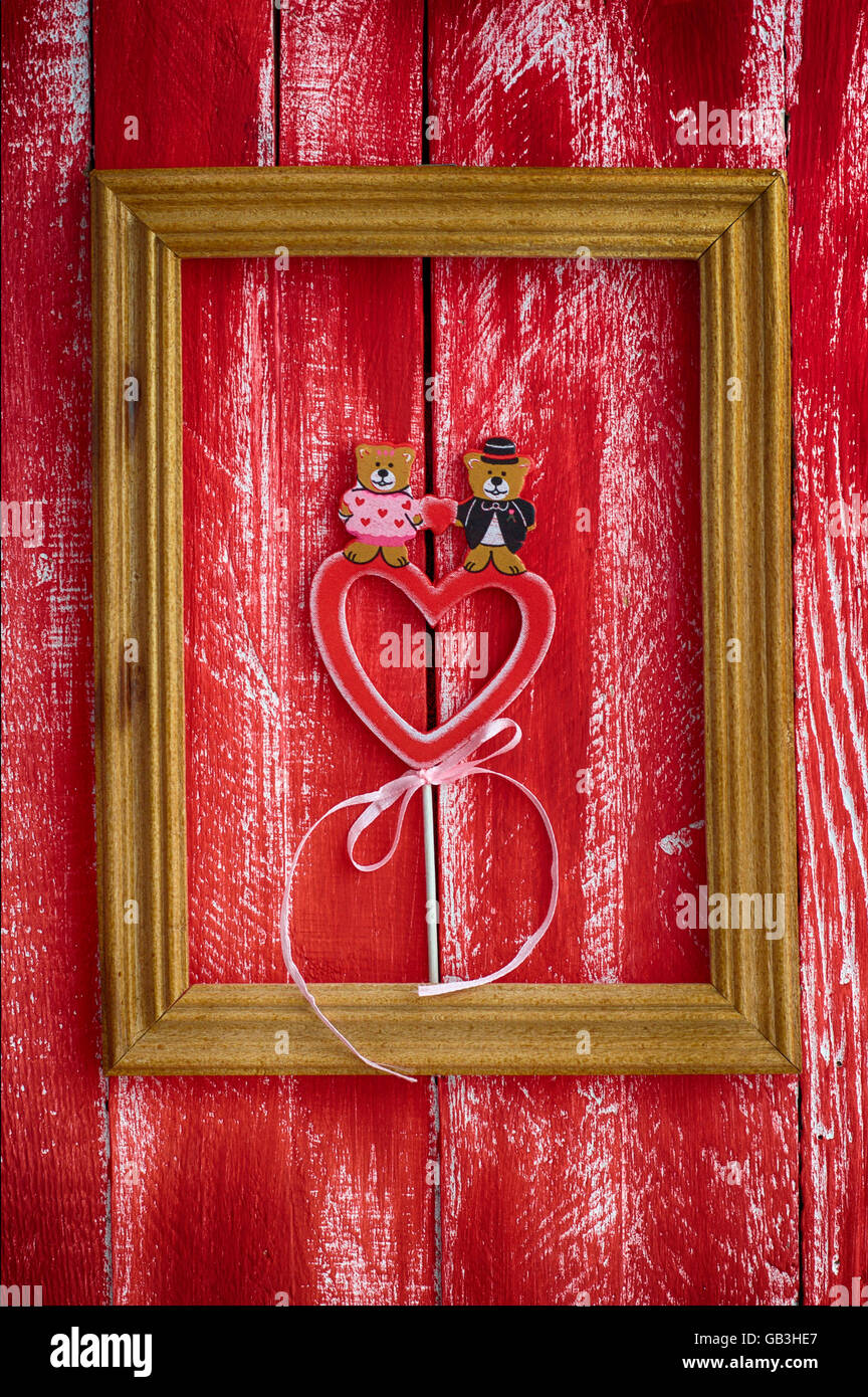 Wooden frame with carved wooden heart in red on a wooden vintage