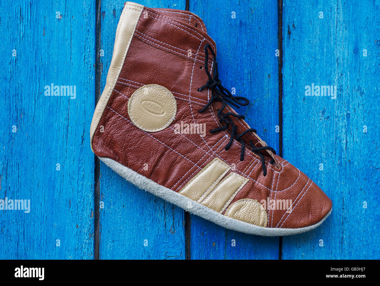 Retro shoes athlete in wrestling, on a wooden blue background Stock Photo