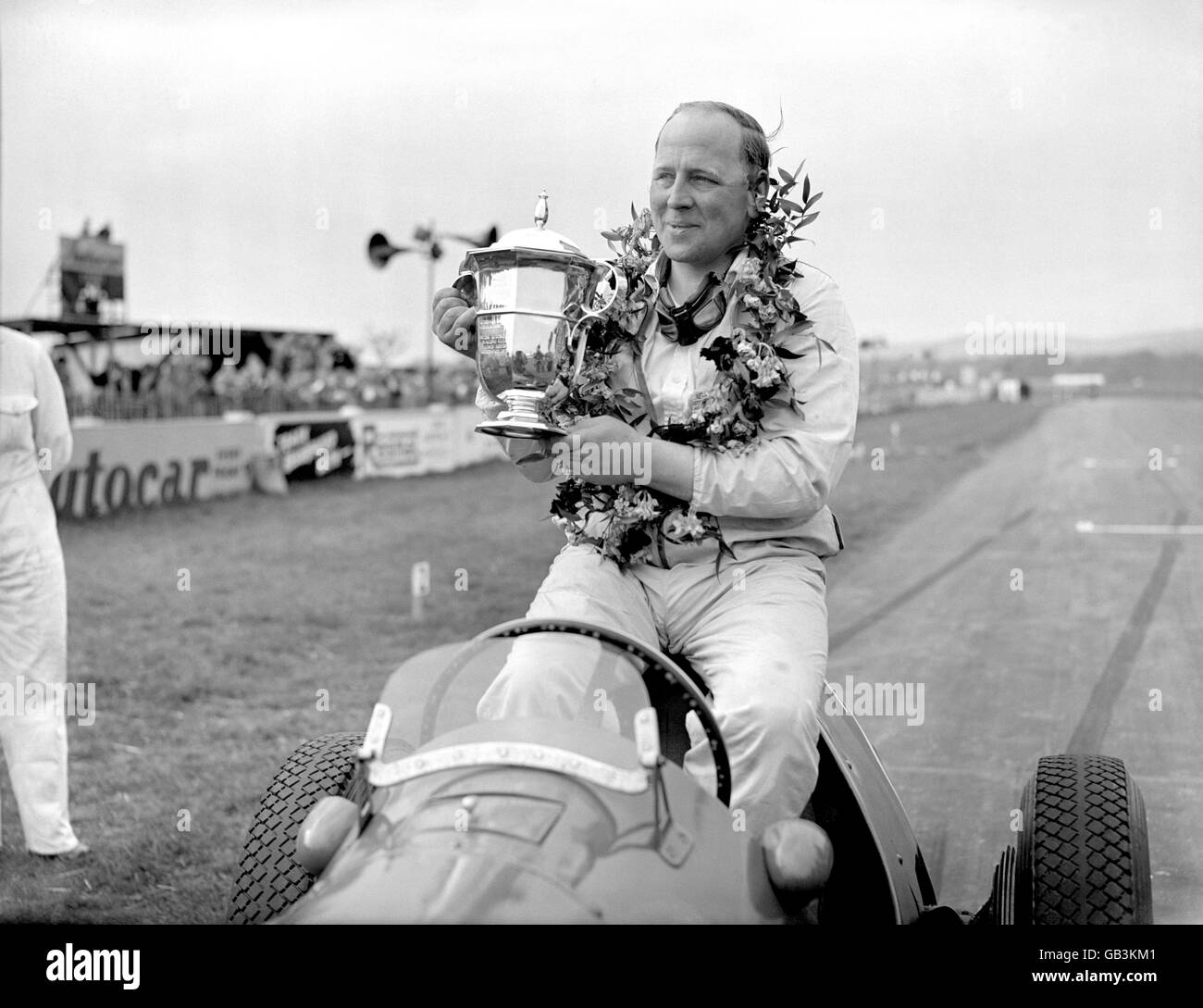 Motor Racing - Festival of Britain Trophy - Final - Goodwood. Reg Parnell shows off the Festival of Britain Trophy after his win in the final Stock Photo