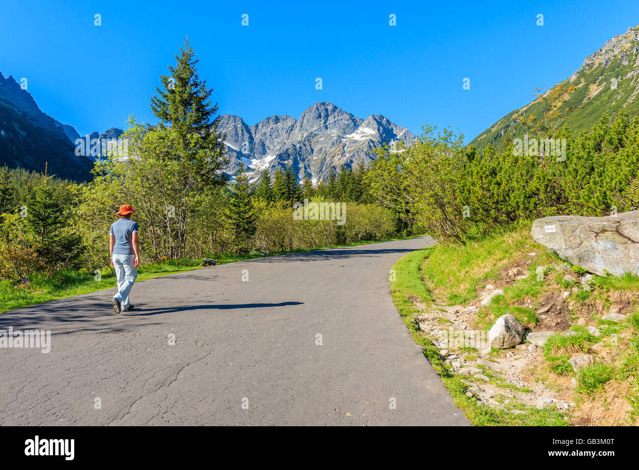 Young tourist walking on road to Morskie Oko lake in Tatra Mountains, Poland Stock Photo