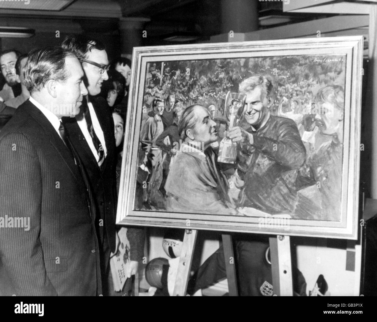 Mr Michael Pitt-Bailey (second l) of Radox presents England manager Sir Alf Ramsey (l) with a painting, by royal portrait artist Vasco Lazzolo, of the moment when England captain Bobby Moore handed the Jules Rimet Trophy to Ramsey after England's World Cup Final victory over West Germany Stock Photo