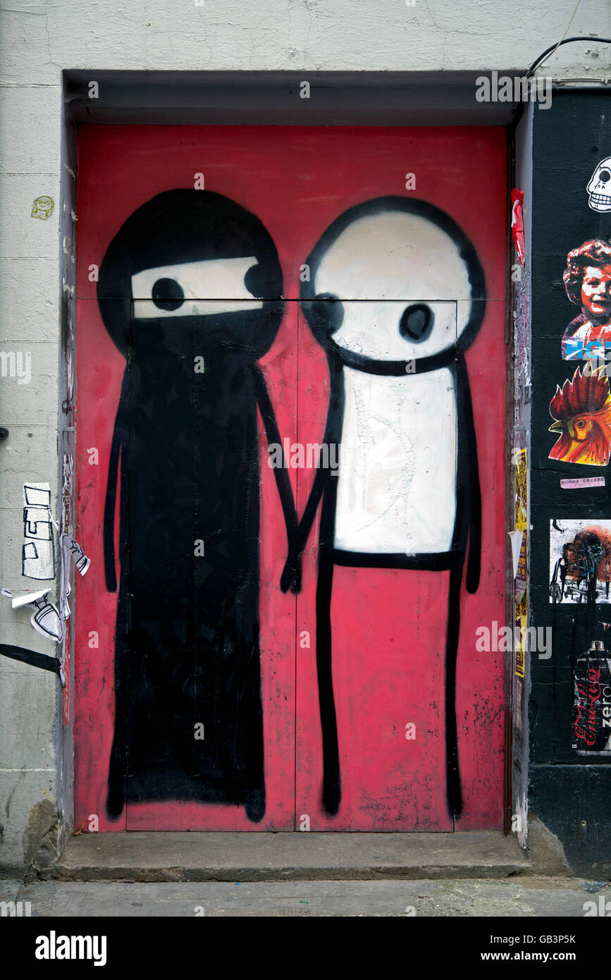 Graffiti by street Artist Stik featuring a man and a woman wearing dressed in a  burka in Shoreditch, London. Stock Photo