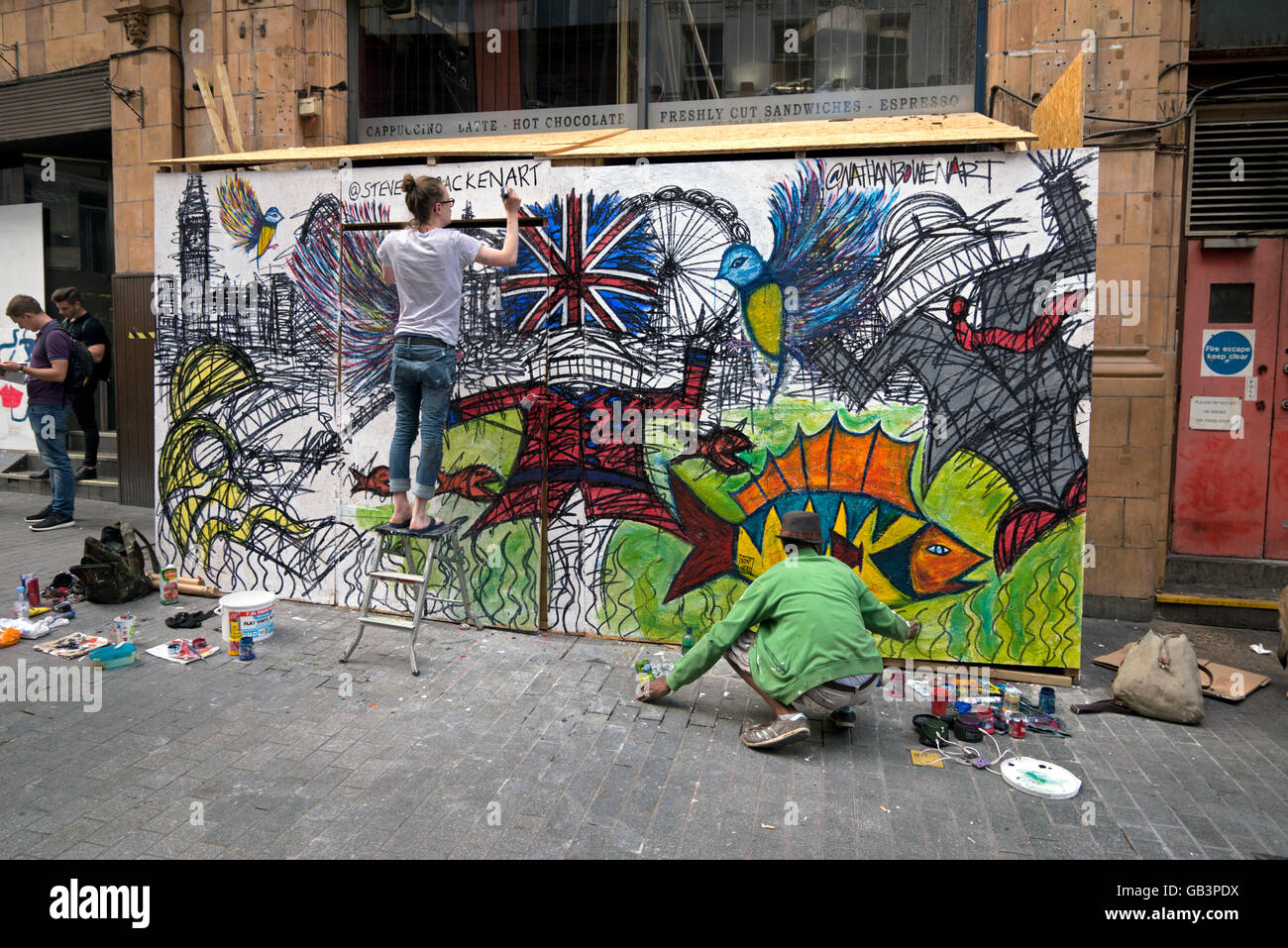 Street artists Steve McCracken and Nathan Bowen working on boards in Argyll Street, London, England, UK. Stock Photo