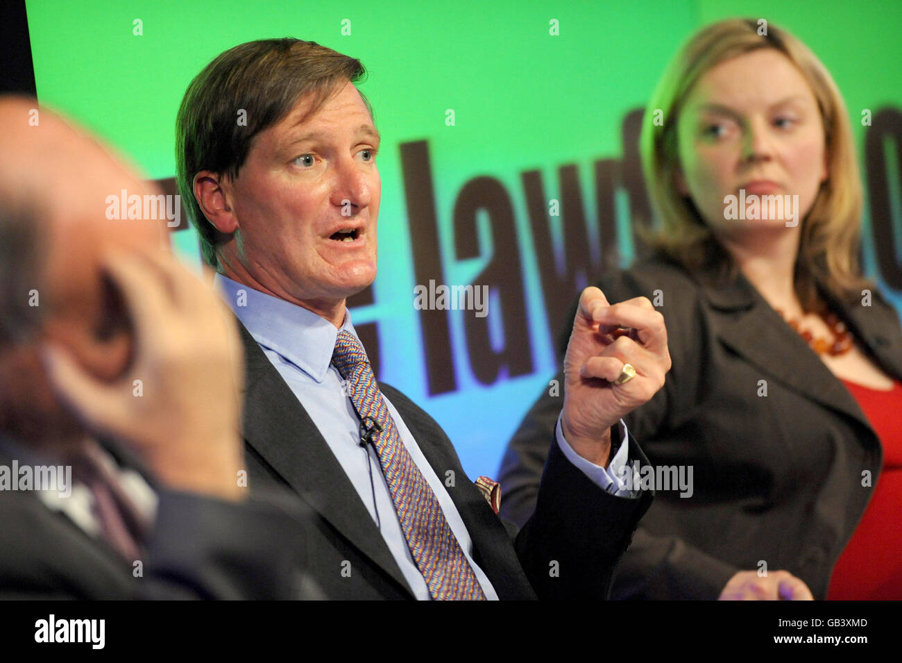 Conservative Shadow Home Secretary Dominic Grieve speaks at the launch Reform's Lawful Society report on the nature of crime and the incentives in the criminal justice system in London, while Elizabeth Truss, Deputy Director of Reform looms on. Stock Photo