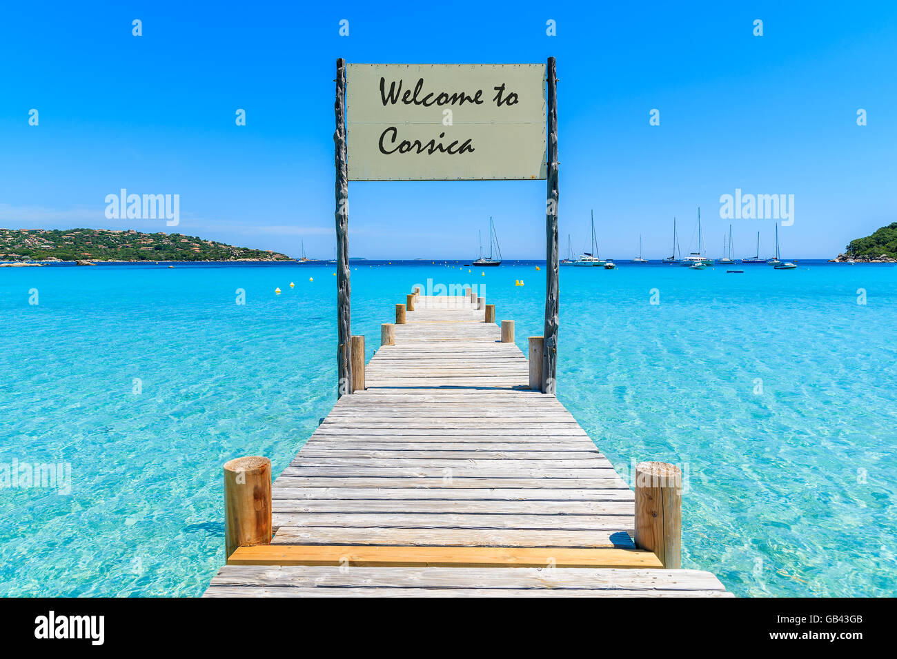 Sign on wooden jetty on Santa Giulia beach with words 'Welcome to Corsica' greeting painted on board, Corsica island, France Stock Photo