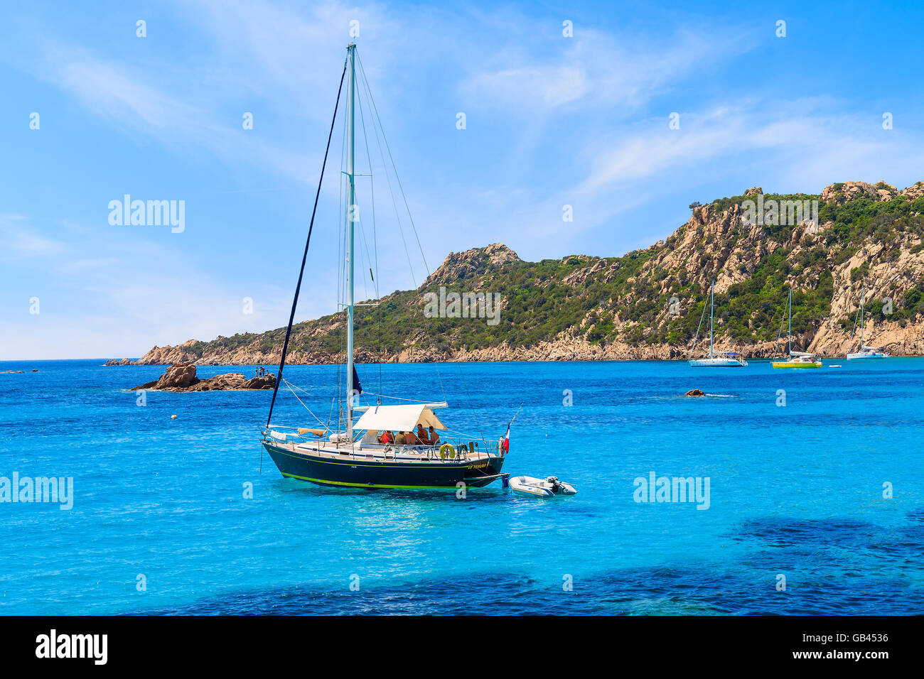 CORSICA ISLAND, FRANCE - JUN 24, 2015: A sailing boat on blue sea mooring in a bay on coast of Corsica island, France. Stock Photo