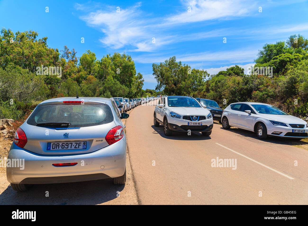 CORSICA ISLAND, FRANCE - JUN 25, 2015: line of cars parking along a road to beach near Bonifacio town in high summer season, Cor Stock Photo