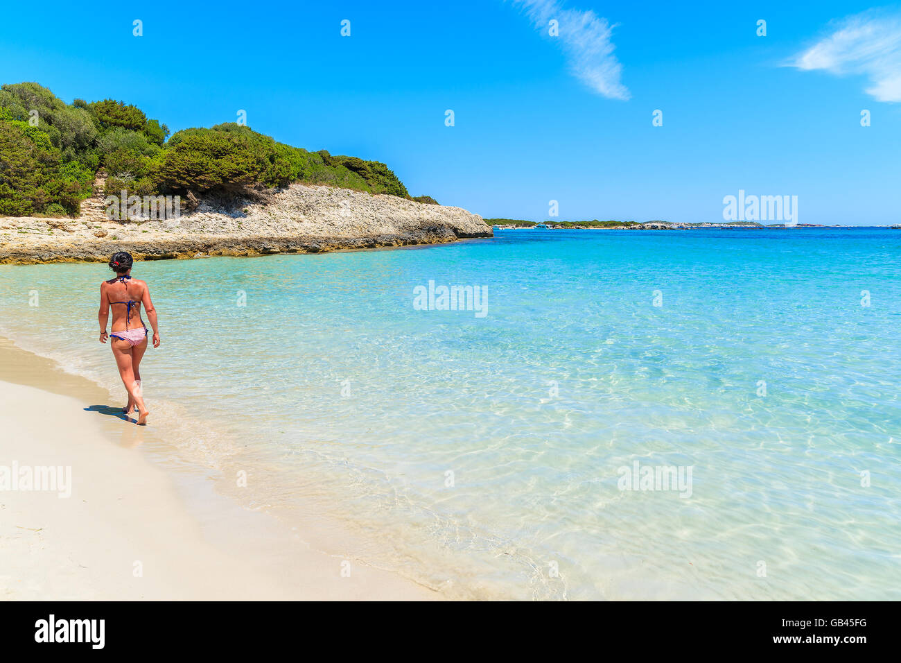 Unidentified attractive young woman in swimsuit walking along beautiful Petit Sperone beach on Corsica island, France Stock Photo