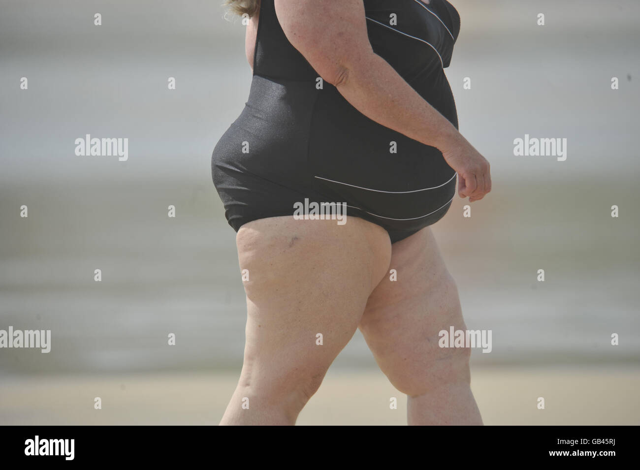 Weather, Sun at the Seaside. A gwoman in a swim suit at Harlyn Bay, Padstow. Stock Photo