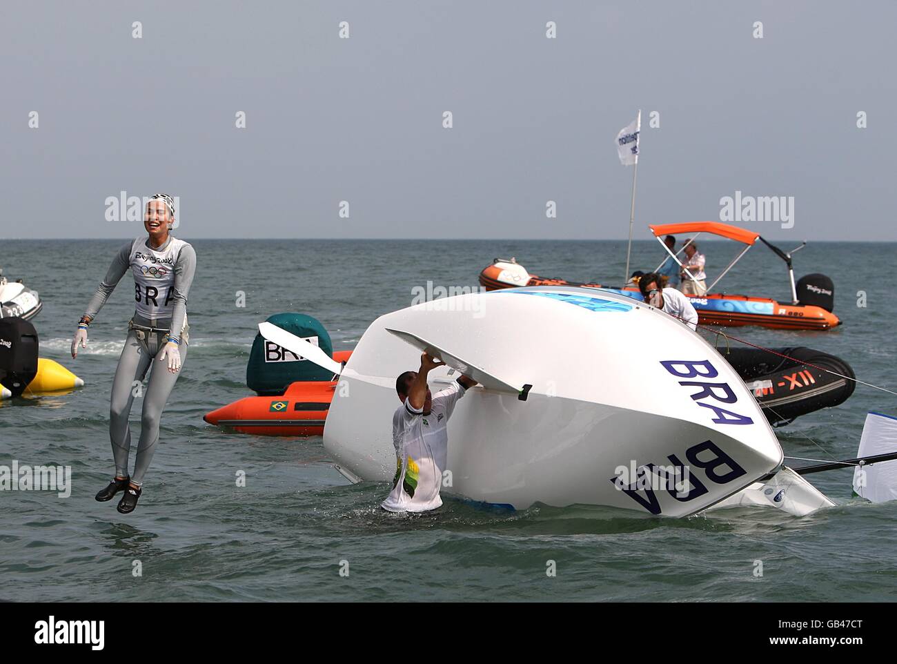 Brazil's Fernanda Oliveira and Isabel Swan bail into the water after their boat capsizes as they celebrate winning their final class race of the Women's 470 class during the 2008 Beijing Olympic Games' Sailing Centre in Qingdao, China. Stock Photo