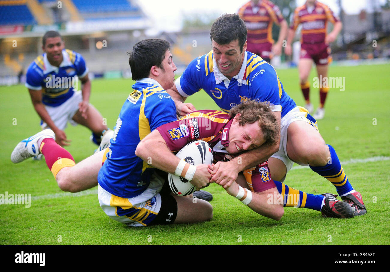 Huddersfield Giants' Danny Kirmond scores under pressure from Leeds Rhinos' Ben Collins and Eric Anselme during the Carnegie Floodlit Nines at Headingley Carnegie Stadium, Leeds. Stock Photo