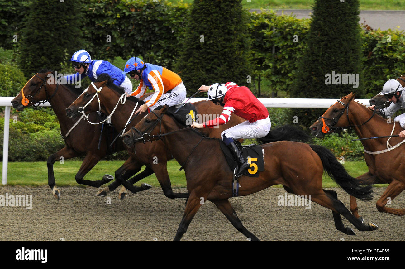 Ethaara ridden by Richard Hills (blue hat) gets up on the rails to win The Bet totepool in the UK and Ireland Handicap Stakes at Kempton Park Racecourse, Middlesex. Stock Photo