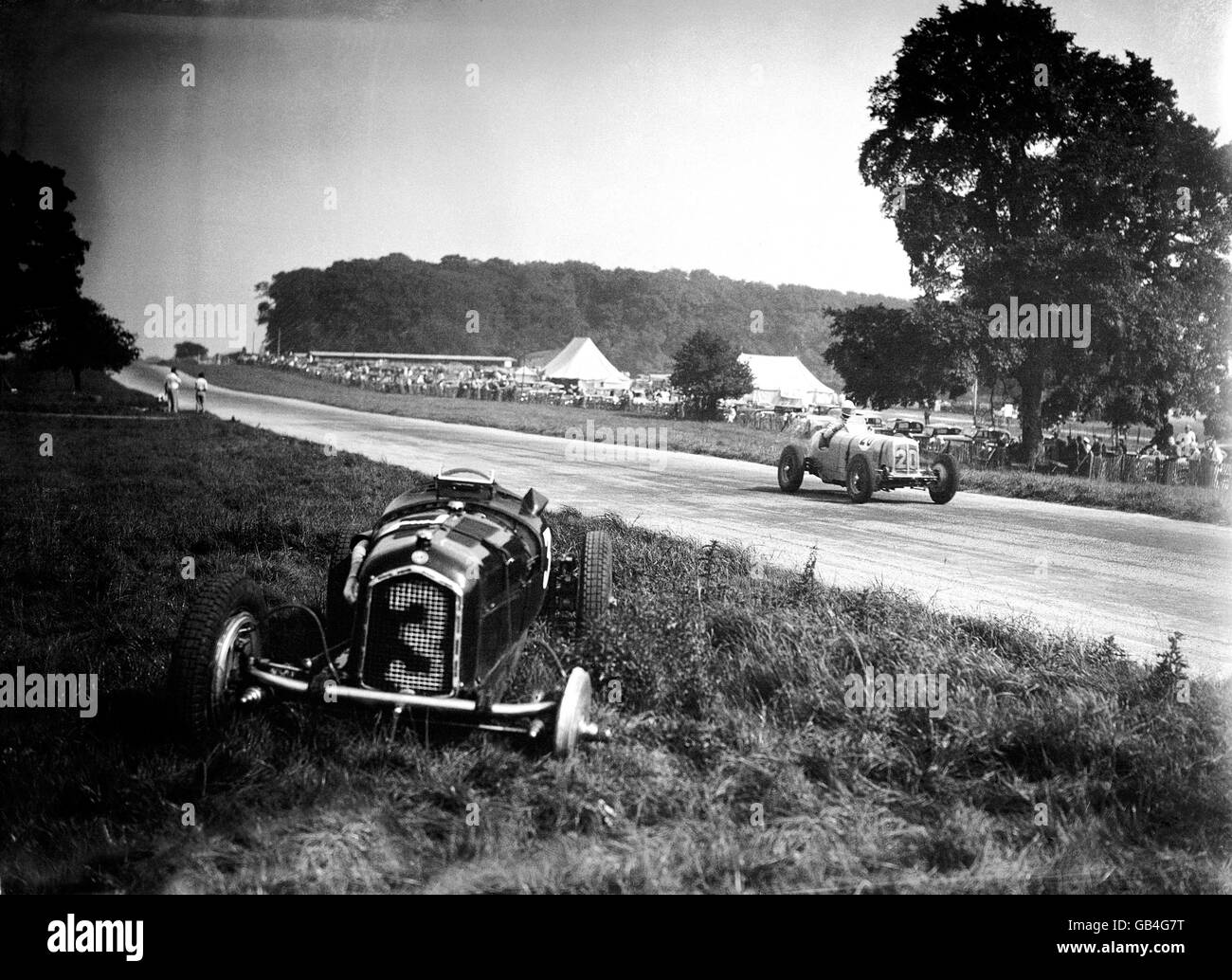 Prince Birabongse Bhanutej Bhanubandh of Siam (B Bira) passes Austin Dobson's crashed Alfa as he flies down Starkey's Hill in his ERA Stock Photo