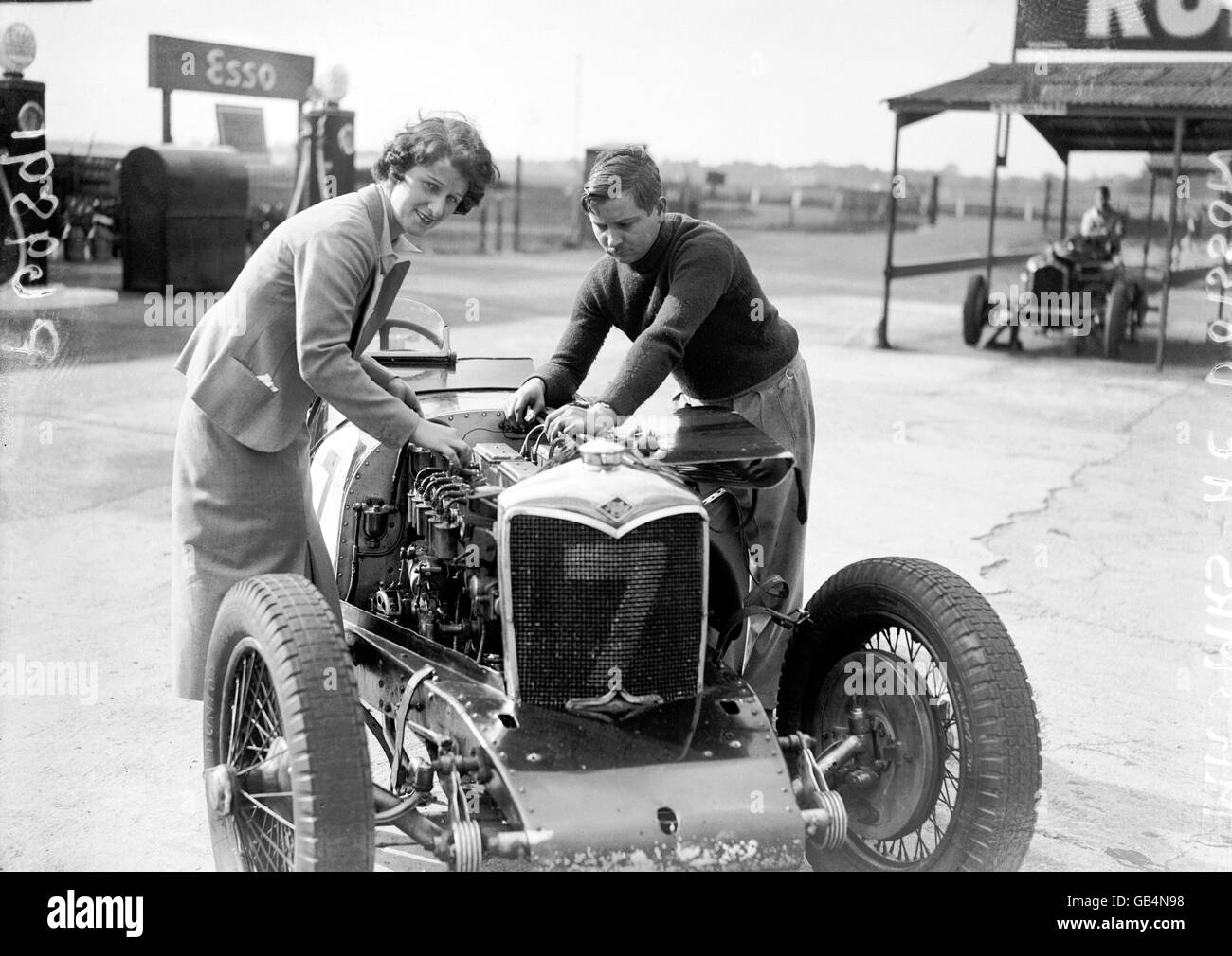 AC Dobson tunes up his car's engine, with a bit of help from his wife Stock Photo