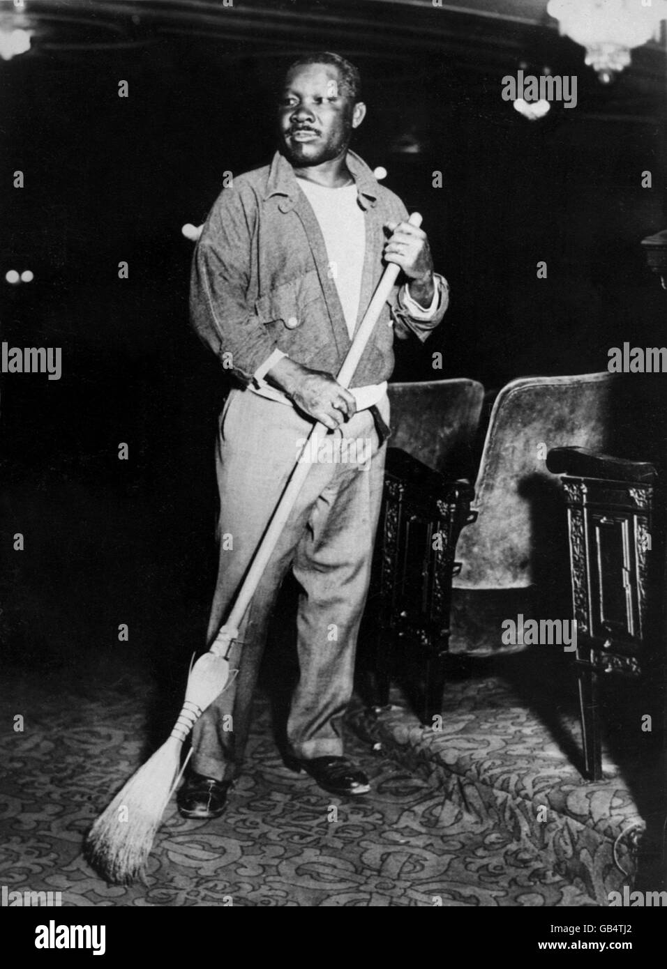 Former World Welterweight Champion Joe Walcott, one of the greatest pound-for-pound fighters of all time, sweeps up at the Imperial Theatre, New York. Stock Photo